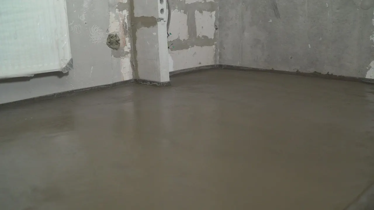 Geëgaliseerde betonvloer in lege woonkamer